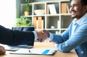 employee from hoa management company in Seattle shakes hand with HOA board member in an office