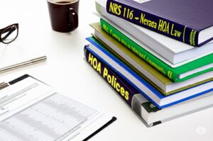 table with books and manuals on HOA laws and policies in Nevada